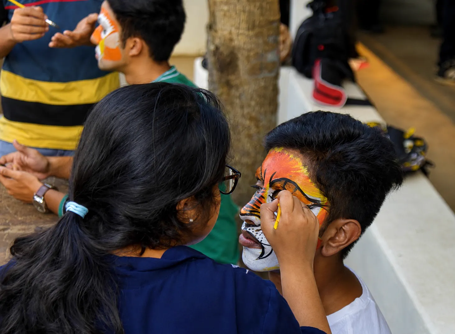 Girl painting young boy