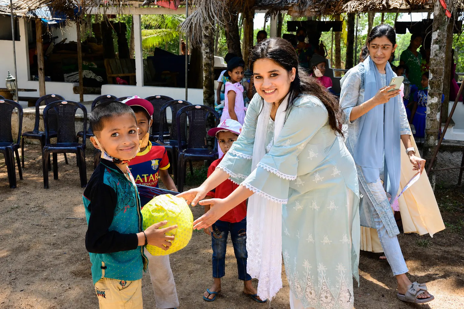 Boy receiving gift from Zoya Akhter